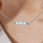 woman wearing diamond and gold three pearl necklace