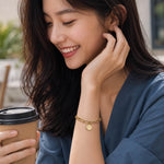 woman wearing a gold coin charm bracelet