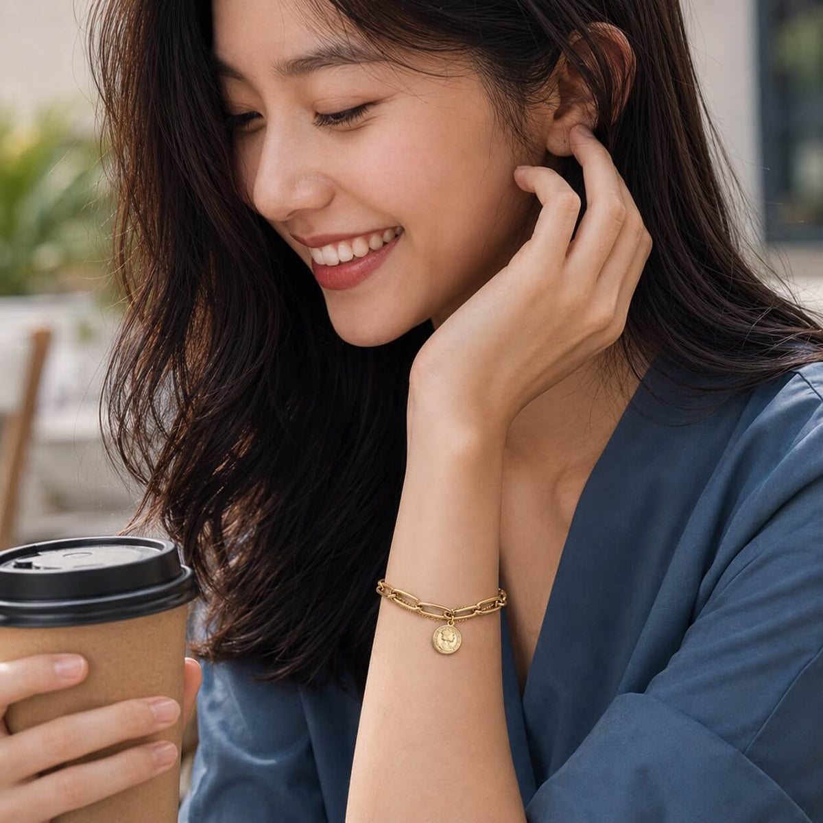 woman wearing a gold coin charm bracelet