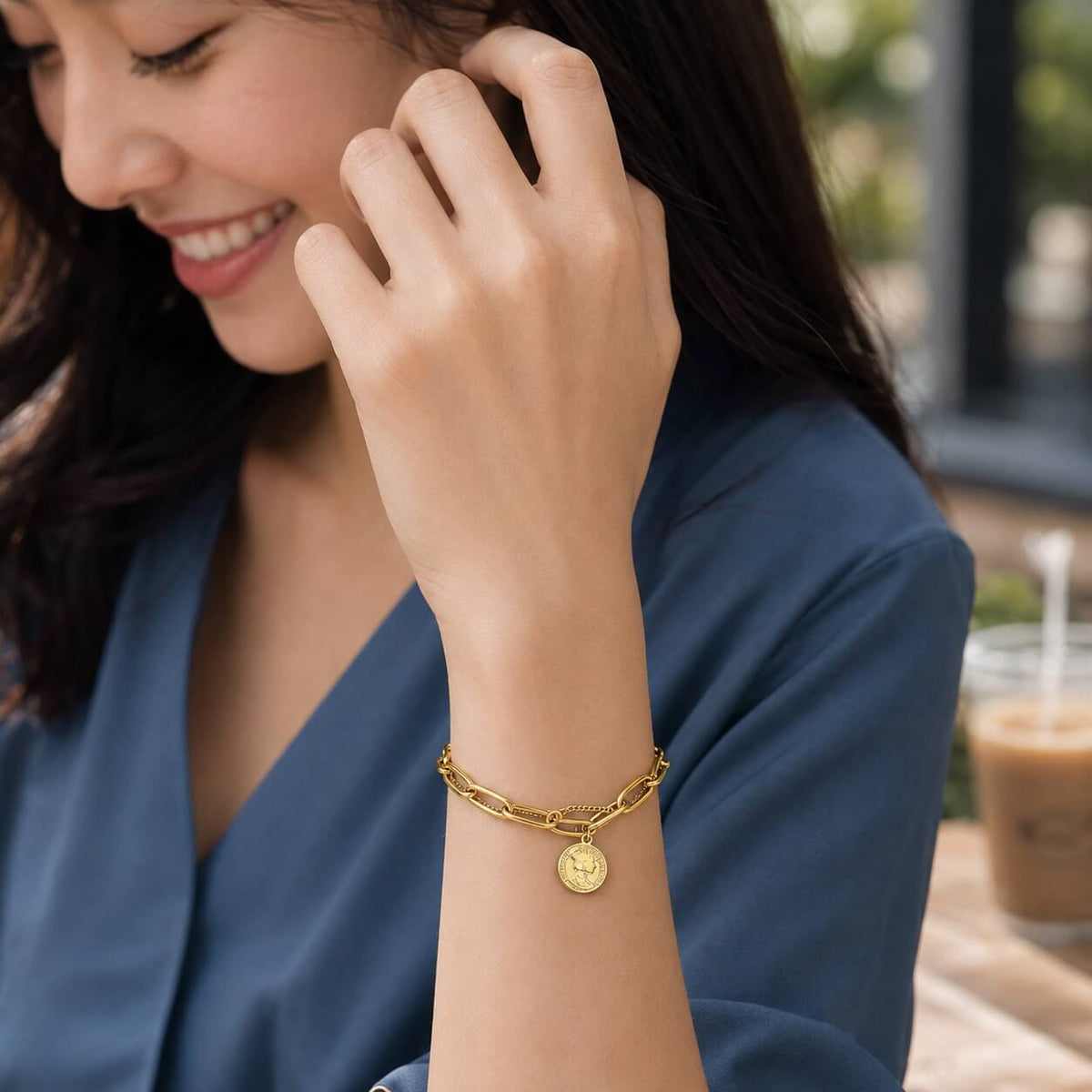 woman wearing a gold coin charm bracelet