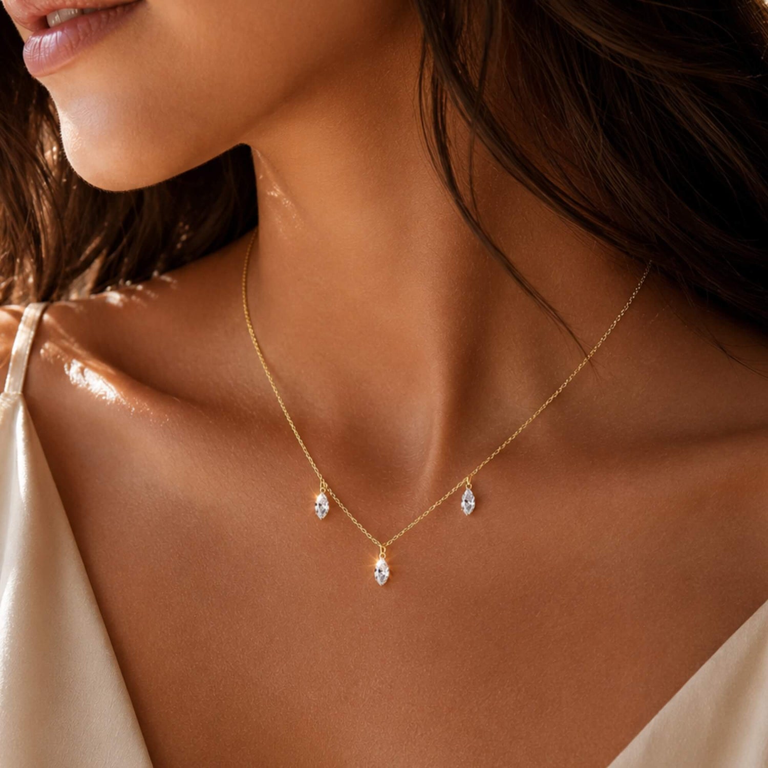 woman wearing a three-stone marquise diamond necklace