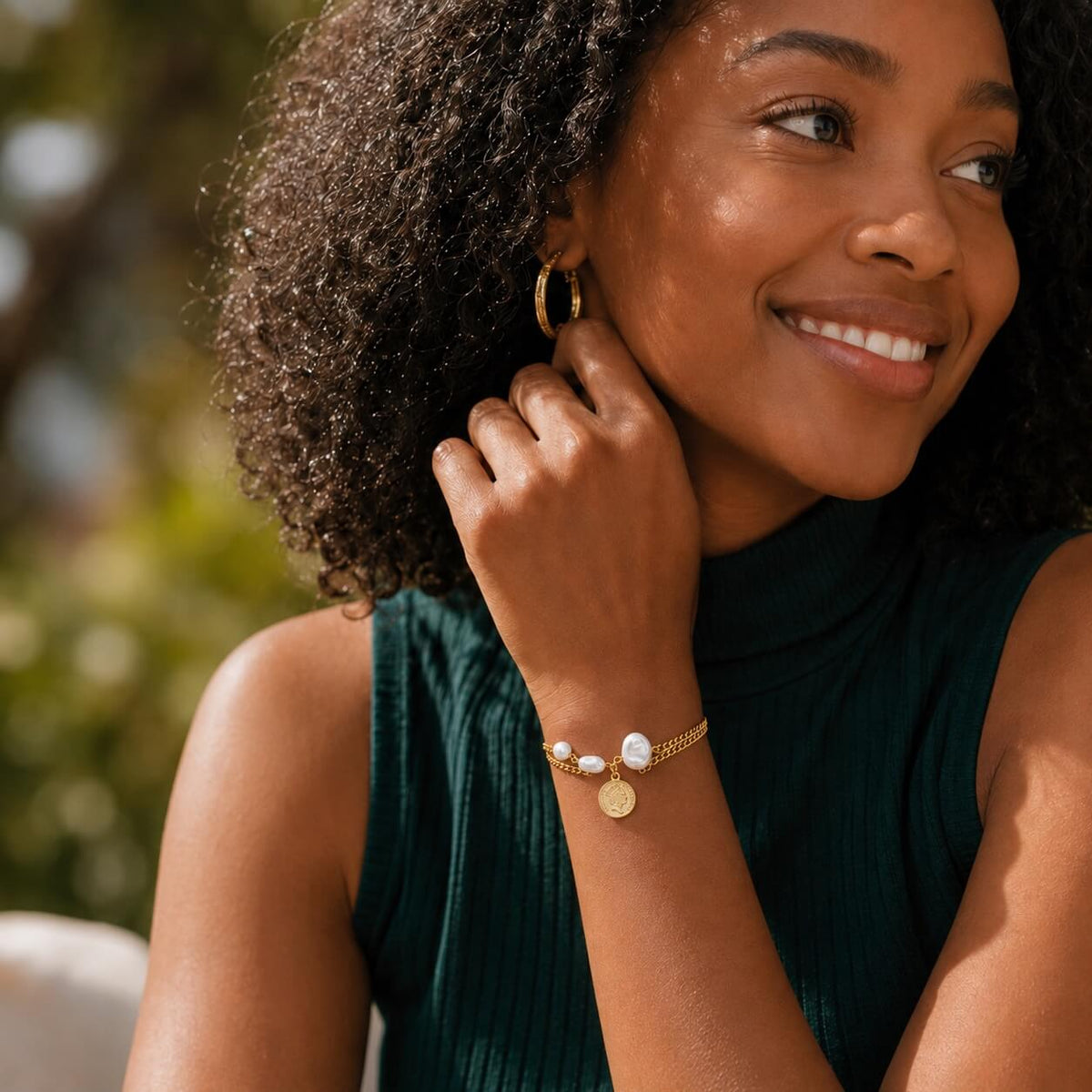 woman wearing a gold pearl charm bracelet