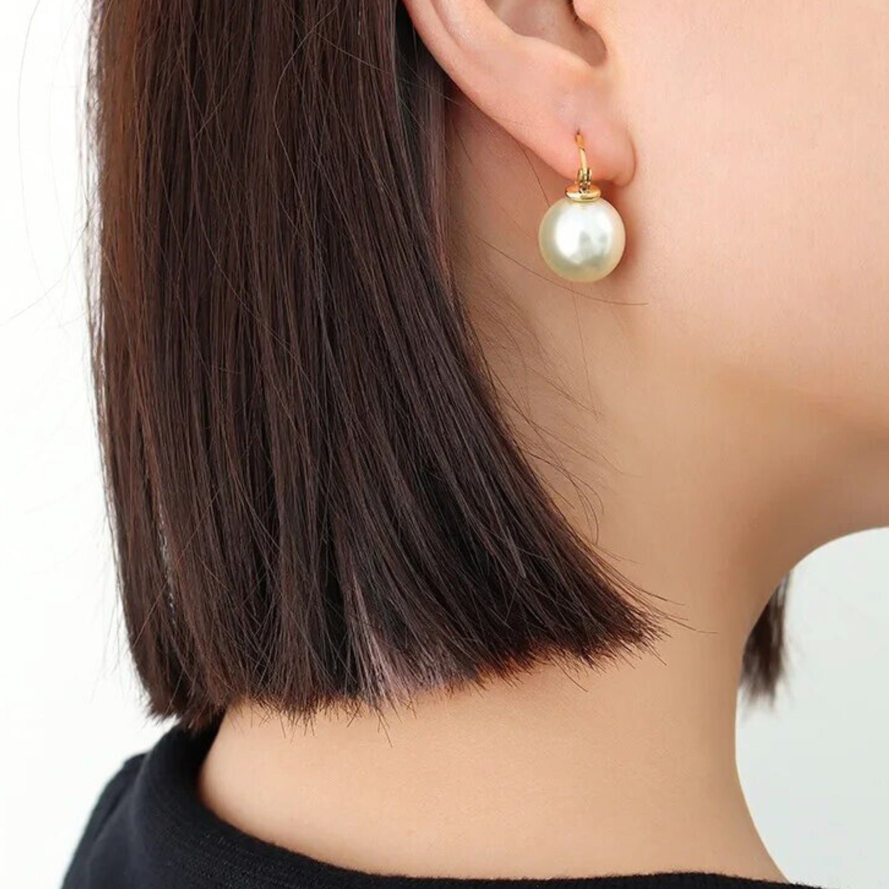 woman wearing pearl stud earrings
