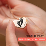 woman holding baby footprint necklace